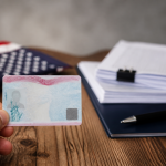 Employment Authorization Document (EAD) work permit card next to Form I-765 paperwork, representing the application process for U.S. work authorization